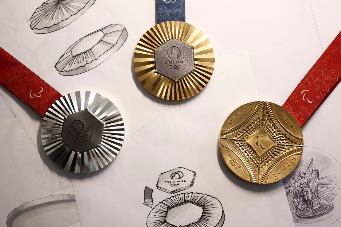 Gold, silver and bronze medals from the 2024 Olympics, resting on paper with sketches of medals and symbols