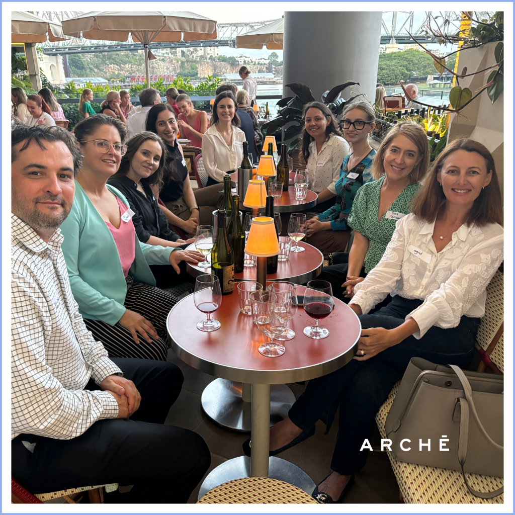 group of people in business casual wear drinking wine with a Brisbane River backdrop